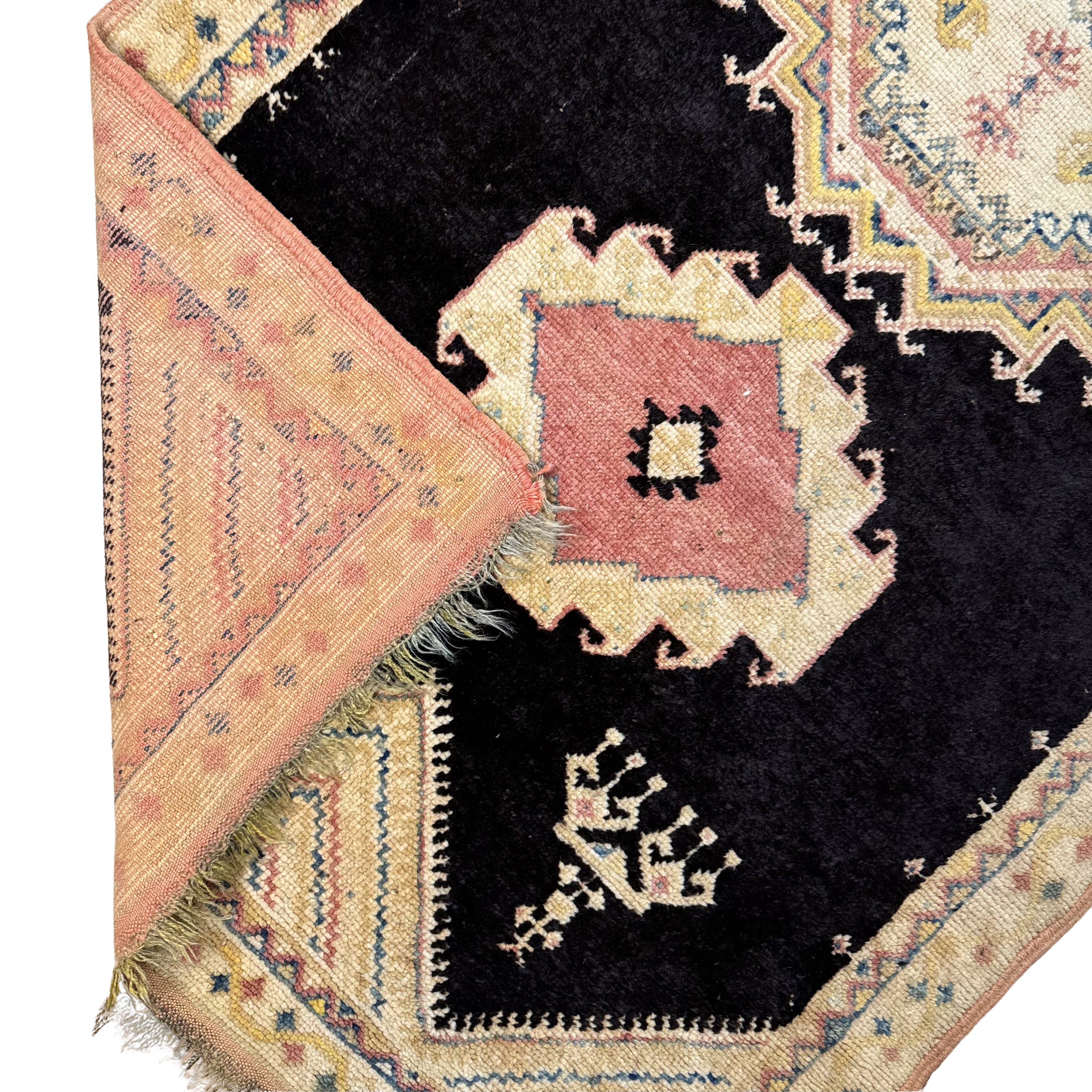Close-up of a patterned rug with intricate designs on a plain background