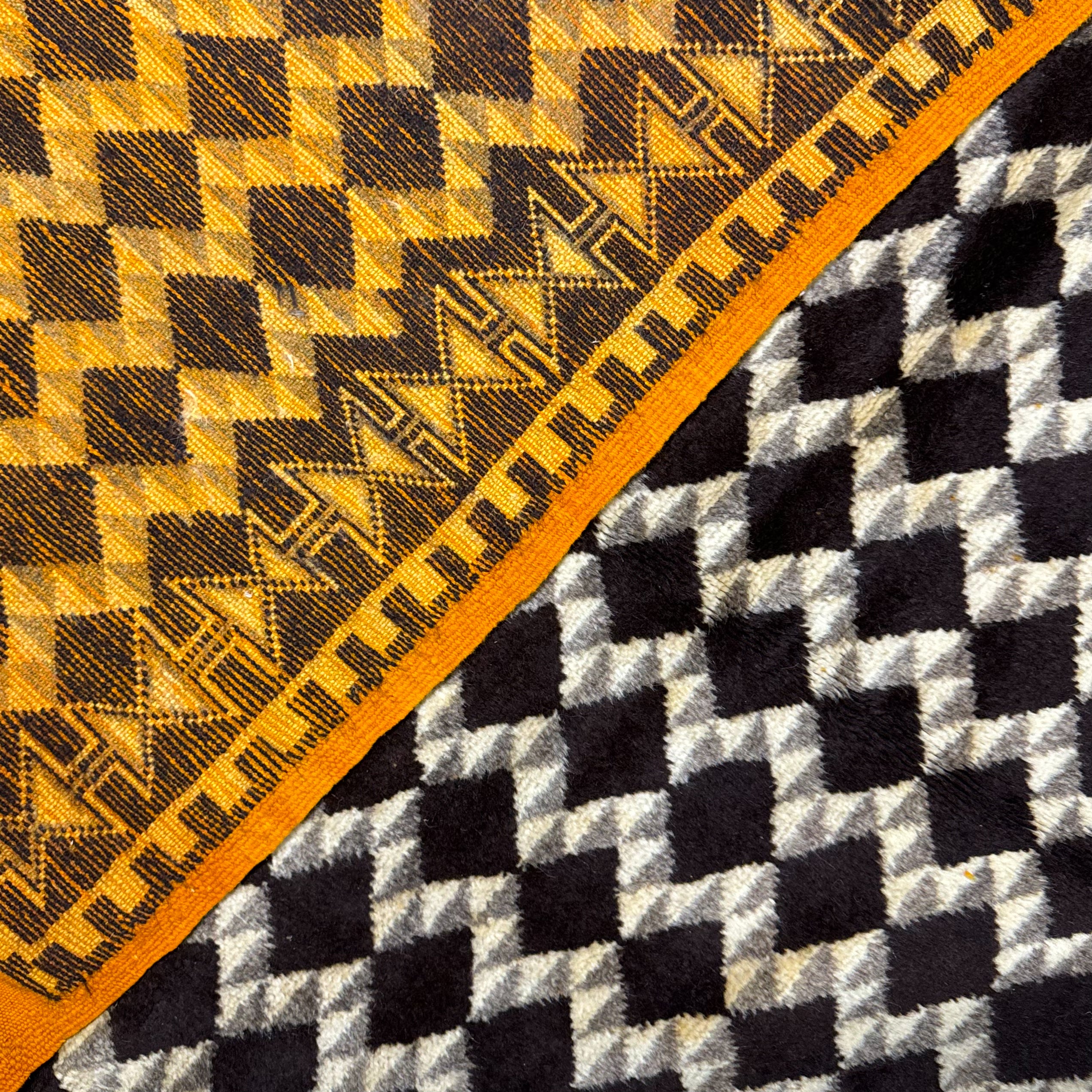 Close-up of patterned fabric with geometric designs in yellow, black, and white.
