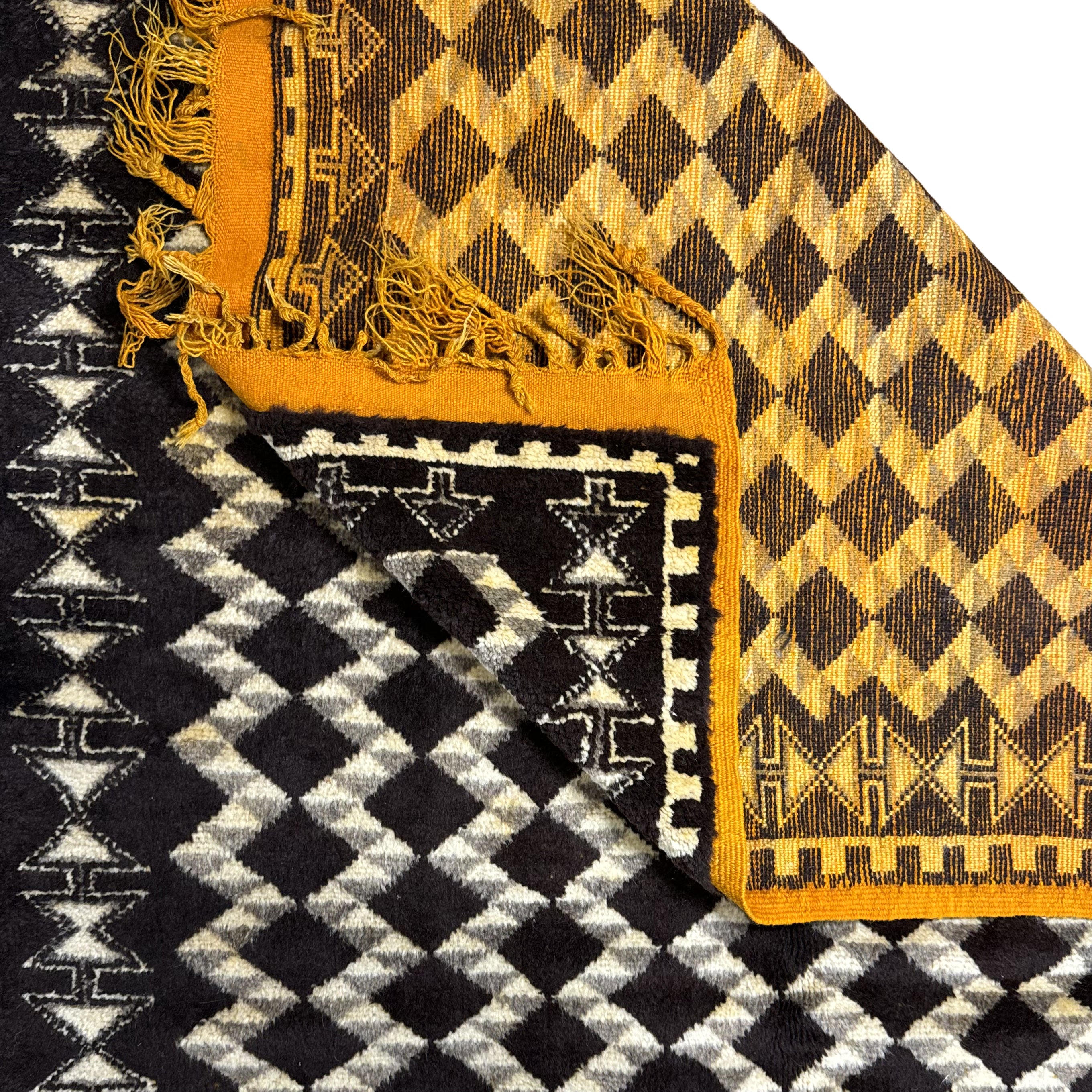 Close-up of patterned fabric with geometric designs in black, white, and yellow.