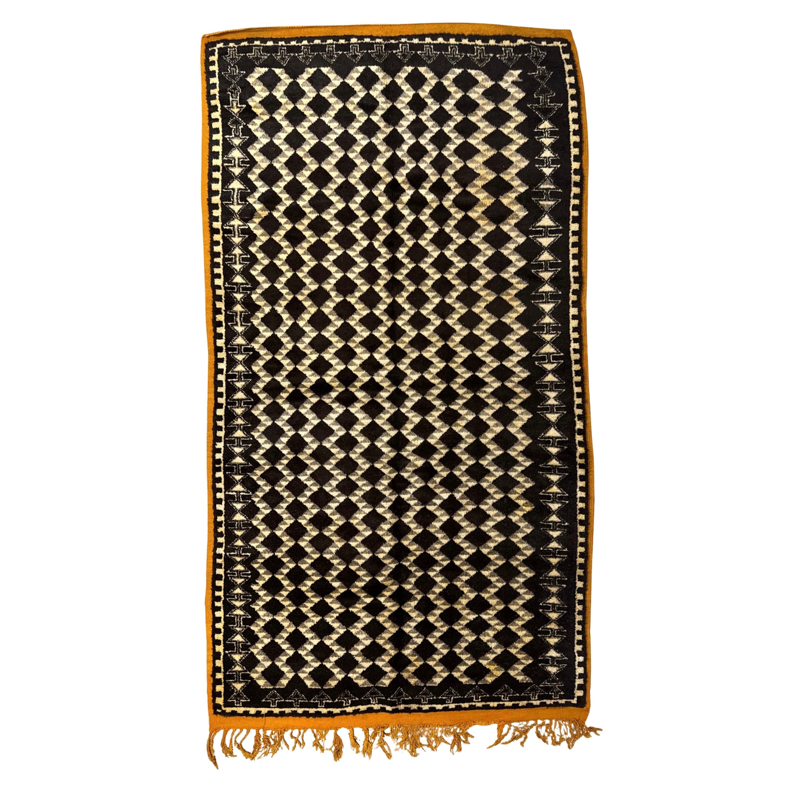 Woven rug with black and beige diamond pattern on a white background